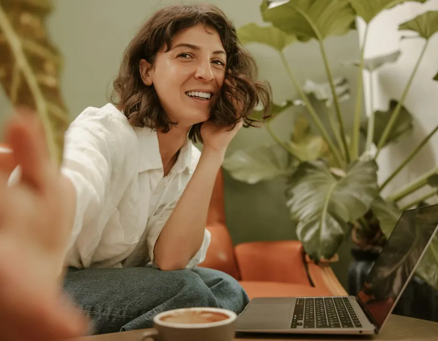 Smiling woman relaxing with her laptop and a coffee